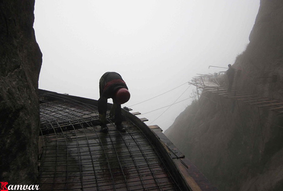 Workers build   a plank road on the side of Shifou Mountain, Huna