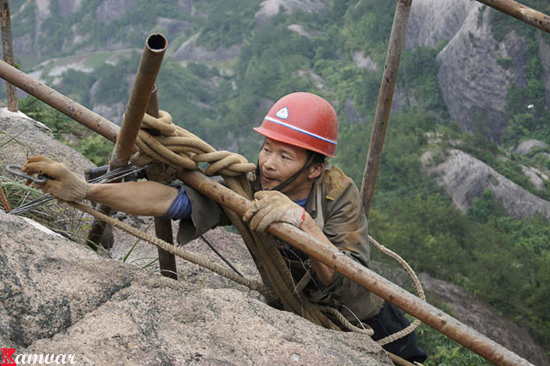 Workers build a plank   road on the side   of  Shifou Mountain, Huna